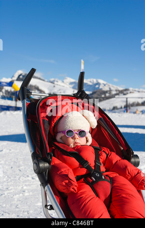 1 anno di età bambina a prendere il sole, Compaccio, Alpe di Siusi, Mont Seuc in ladino, Dolomiti dell Alto Adige, Italia, inverno Foto Stock