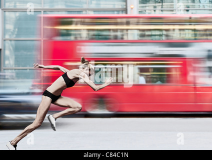 Atleta racing bus sulla strada di città Foto Stock