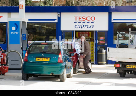 Driver di rifornimento con carburante a un supermercato Tesco Express stazione di benzina. Foto Stock