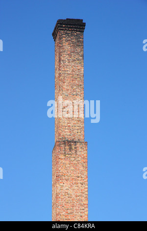 Uno arancione mattone tubo sul cielo blu. ambientale il concetto di costruzione Foto Stock