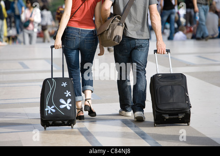 Giovane passeggiate all'aperto con trolley Foto Stock