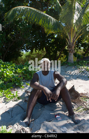 Madagascar uomo seduto spiaggia di Nosy Tanikely vicino a Nosy Be Africa Foto Stock