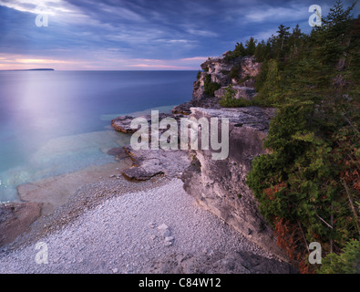 Tramonto stupendo scenario del Georgian Bay spiaggia rocciosa e scogliere abitate da alberi di cedro. Bruce Peninsula National Park, Ontario Foto Stock