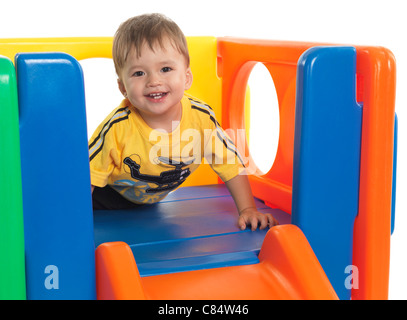 Felice circa un anno e mezzo il vecchio bambino salendo una diapositiva. Isolato su sfondo bianco. Foto Stock