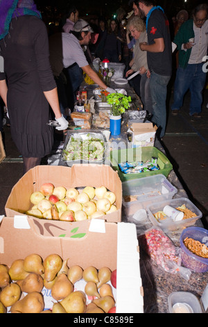 Volontari a occupare Wall Street manifestanti di alimentazione durante la notte da passare fuori cibo donato a Zuccotti Park di New York City Foto Stock