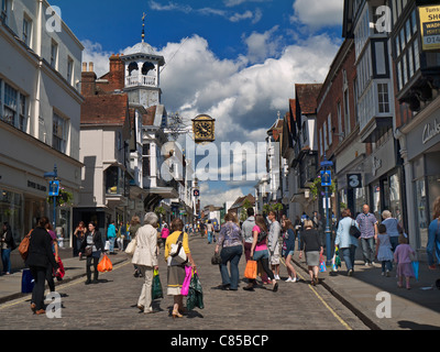 GUILDFORD Shoppers è affollata di persone nella storica High Street, acciottolata e trafficata, con il famoso orologio, che si gode il sole primaverile di Guildford, Surrey, Regno Unito
