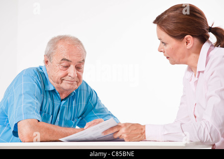 L uomo e la donna a discutere di documenti cartacei Foto Stock