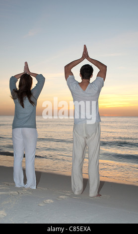 Giovane fare yoga sulla spiaggia, Reef Playacar Resort e Spa, Playa del Carmen, Messico Foto Stock