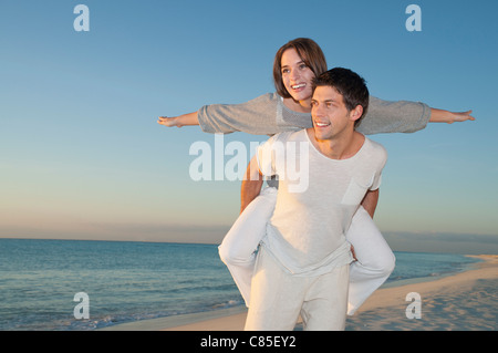 Piggybacking uomo donna sulla spiaggia, Reef Playacar Resort e Spa, Playa del Carmen, Messico Foto Stock