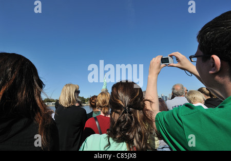I turisti a bordo di una statua di Traghetti Crociere approccio la Statua della Libertà su Liberty Island nel porto di New York. Foto Stock