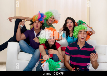 Gli amici a guardare una partita di cricket in tv Foto Stock