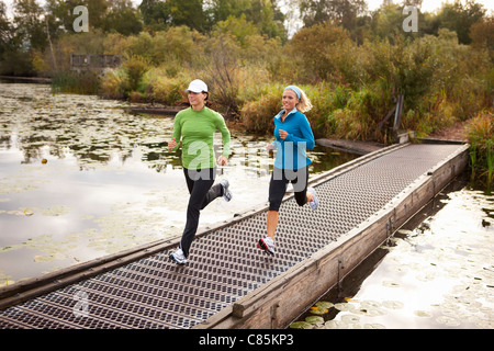 Due donne Jogging attraverso Park Foto Stock