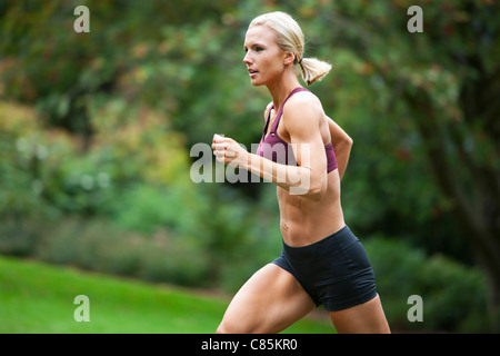 Donna Jogging attraverso Park, Seattle, Washington, Stati Uniti d'America Foto Stock