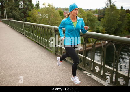 Donna Jogging attraverso il ponte, Seattle, Washington, Stati Uniti d'America Foto Stock