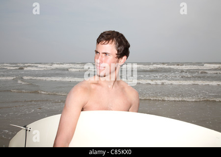 Uomo con la tavola da surf, Galveston, Galveston Island, Galveston County, Texas, Stati Uniti d'America Foto Stock