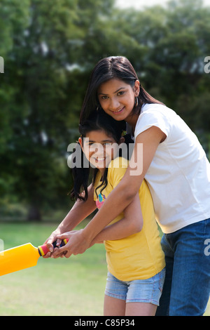 Madre e figlia a giocare a cricket Foto Stock