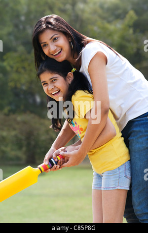 Madre e figlia a giocare a cricket Foto Stock