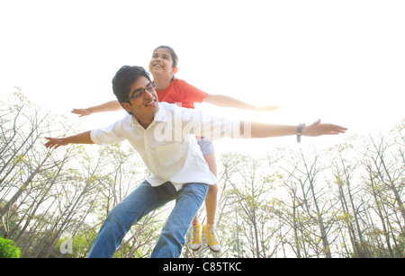 Ragazza in equilibrio su i suoi padri indietro Foto Stock