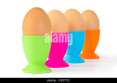 Uova sode in uova colorate tazze in una fila isolato Foto Stock