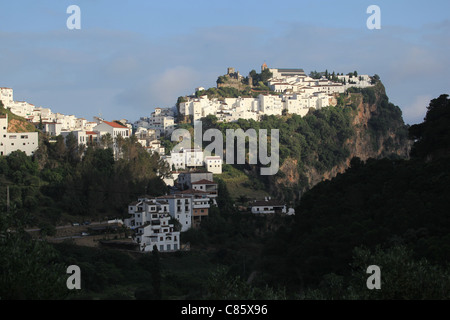 Nel tardo pomeriggio la luce del sole splende sulle bianche case dipinte e castello moresco di Casares, [pueblo blanco] in Andalusia, Spagna Foto Stock