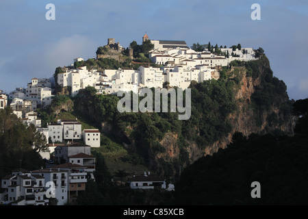 Nel tardo pomeriggio la luce del sole splende sulle bianche case dipinte e castello moresco di Casares, [pueblo blanco] in Andalusia, Spagna Foto Stock