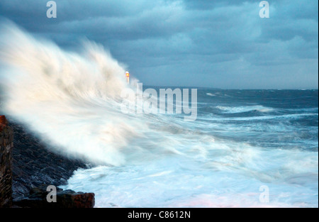 Onde che si infrangono sulle Porthcawl pier, nel Galles del Sud. Foto Stock