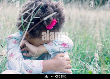 Bambina appoggiato la testa sul braccio Foto Stock