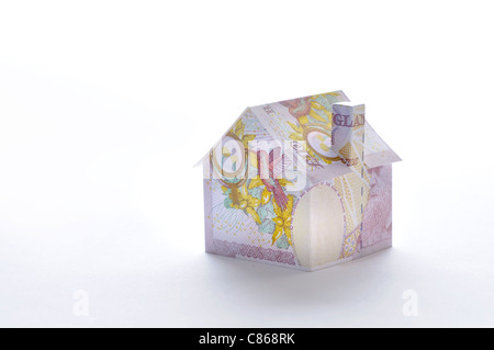 Modello di casa piegato con British pound banconota Foto Stock