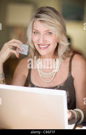 Donna anziana shopping su internet Foto Stock