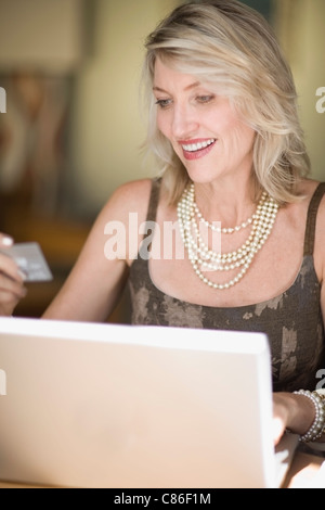 Donna anziana shopping su internet Foto Stock