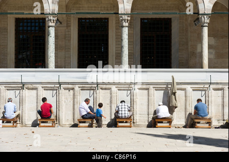 Uomini musulmani lavando loro i piedi prima di pregare in Moschea Suleymaniye, Istanbul, Turchia Foto Stock