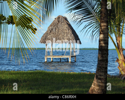 Rifugio tropicale su acqua con Palm con il tetto di paglia del tetto, sul mare dei Caraibi, America centrale e di Panama Foto Stock