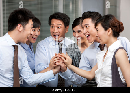 I colleghi di mettere le loro mani in Foto Stock