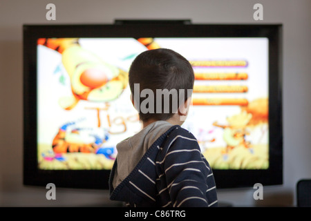 4 anno vecchio ragazzo guardando cartoni animati in TV Foto Stock