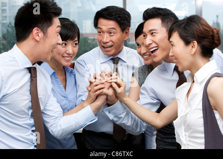 I colleghi di mettere le loro mani in Foto Stock