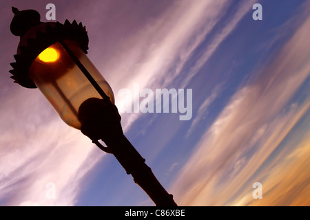 Un lampione accensione durante il tramonto per illuminare la notte Foto Stock