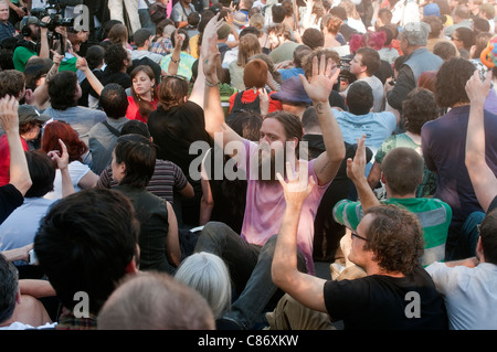 Occupare Wall Street contestatori dei bracci di sollevamento e muovere le dita in approvazione nel corso di una Assemblea Generale Foto Stock