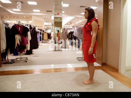 Giovane donna cercando su un abito in un negozio Bloomingdales, Washington DC, Stati Uniti d'America Foto Stock