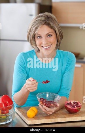 Donna di mangiare il Melograno Foto Stock