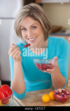 Donna di mangiare il Melograno Foto Stock