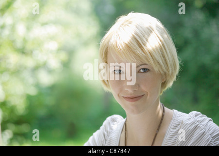 In Germania, in Baviera, Schaeftlarn, ravvicinata di una giovane donna nel parco, ritratto, sorridente Foto Stock