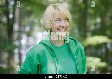 In Germania, in Baviera, Schaeftlarn, ravvicinata di una giovane donna nella foresta, sorridente Foto Stock