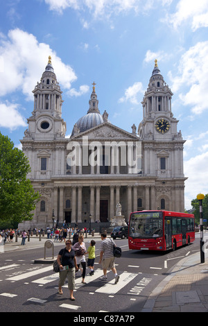 Bus rosso e i pedoni sull' attraversamento fuori dalla cattedrale di St Paul, City of London, England, Regno Unito, Regno Unito, GB Gran Bretagna, Foto Stock