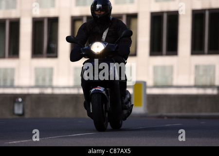 Un motociclista in viaggio lungo una strada di Londra Foto Stock