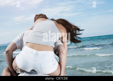 Spagna, Maiorca, giovane donna che porta sul retro a beach Foto Stock