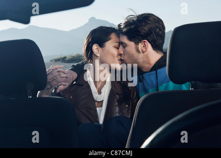 Spagna, Maiorca, coppia giovane kissing ogni altro in cabriolet auto, close up Foto Stock