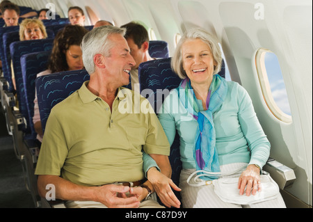 Germania - Monaco di Baviera, gruppo di passeggeri in classe economy aereo di linea, sorridente Foto Stock