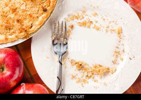 Abstract di overhead di mele, torta, piastra vuota con briciole rimanenti Foto Stock