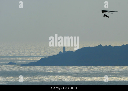 Un deltaplano utilizza i venti sulla costa del Devon meridionale affacciato sulla Baia di inizio ed il punto di inizio. Foto Stock