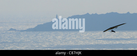 Un deltaplano utilizza i venti sulla costa del Devon meridionale affacciato sulla Baia di inizio ed il punto di inizio. Foto Stock